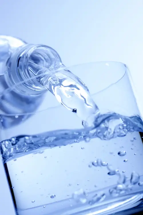 plastic water bottle pouring into glass