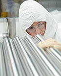 woman inspecting stainless steel pipe tubing